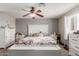 Main bedroom with floral bedding, white dresser, and ceiling fan at 6033 S 19Th Pl, Phoenix, AZ 85042