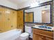 Clean bathroom with yellow tile and a wooden vanity at 6212 S 37Th St, Phoenix, AZ 85042