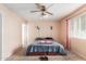 Cozy bedroom featuring a ceiling fan and large window at 6252 E Billings St, Mesa, AZ 85205