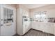 Kitchen with white cabinets, oven, microwave and exterior door at 6252 E Billings St, Mesa, AZ 85205