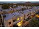 Aerial view of modern townhomes showcasing a well-lit community at dusk at 6301 N 12Th St # 8, Phoenix, AZ 85014