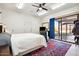 Bedroom with sliding glass door to patio, ceiling fan, and red rug at 6469 S Alameda Rd, Gold Canyon, AZ 85118