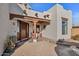 Inviting front entrance with a covered patio, brick flooring, and potted plants at 6469 S Alameda Rd, Gold Canyon, AZ 85118