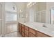 Bathroom with double vanity, wood cabinets, and a shower at 8527 W Aster Dr, Peoria, AZ 85381