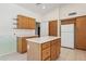 Kitchen with island, wood cabinets, and white appliances at 8527 W Aster Dr, Peoria, AZ 85381