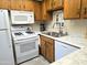 Galley-style kitchen with white appliances and wood cabinetry at 867 E Lancaster Cir, Florence, AZ 85132