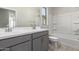 Bathroom featuring double sinks, a window, and a shower-tub combo at 9227 E Sector Dr, Mesa, AZ 85212