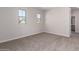 Bright bedroom with carpeted floors, two windows, and a neutral color scheme at 9227 E Sector Dr, Mesa, AZ 85212