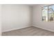 Empty bedroom with neutral carpet, a bright window, base molding, and electrical outlets awaiting personalized touches at 9227 E Sector Dr, Mesa, AZ 85212