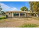 Tan single story home with sunroom and desert landscaping at 9502 W Shasta Dr, Sun City, AZ 85351