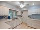 White kitchen with ample cabinetry and tile flooring at 9502 W Shasta Dr, Sun City, AZ 85351