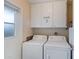 Laundry room with washer, dryer and overhead cabinets at 9502 W Shasta Dr, Sun City, AZ 85351