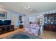 Living room with floral sofas and a large-screen TV at 9502 W Shasta Dr, Sun City, AZ 85351