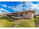 Tan house exterior with a screened patio and well-maintained lawn at 9920 W Shasta Dr, Sun City, AZ 85351