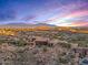 Sunset aerial view of a luxury home with mountain backdrop at 10473 E Greythorn Dr, Scottsdale, AZ 85262