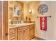 Bathroom with wood vanity, granite countertop, and decorative mirror at 10473 E Greythorn Dr, Scottsdale, AZ 85262