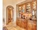 Butlers pantry with wood cabinets, granite countertops and wine storage at 10473 E Greythorn Dr, Scottsdale, AZ 85262