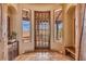 Entryway with a rustic wooden door and views of the desert landscape at 10473 E Greythorn Dr, Scottsdale, AZ 85262