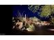 Night view of home's exterior, showcasing landscaping and lighting at 10473 E Greythorn Dr, Scottsdale, AZ 85262