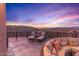 Relaxing patio with lounge chairs, a stunning sunset, and scenic views at 10473 E Greythorn Dr, Scottsdale, AZ 85262