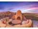 Outdoor patio features a circular seating area, a fireplace, and scenic views at 10473 E Greythorn Dr, Scottsdale, AZ 85262