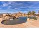 Stunning pool and waterfall feature with desert landscape at 10473 E Greythorn Dr, Scottsdale, AZ 85262
