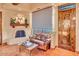 Cozy sitting area with leather couch, wood coffee table, and fireplace at 10473 E Greythorn Dr, Scottsdale, AZ 85262