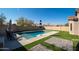 Inviting backyard oasis featuring a sparkling pool, artificial turf, and paved patio areas at 10789 W Yearling Rd, Peoria, AZ 85383