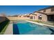 Relaxing backyard with a refreshing pool, lush green lawn, and a view of the home at 10789 W Yearling Rd, Peoria, AZ 85383