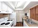 Galley kitchen with white appliances and wood shelving at 10828 N Biltmore Dr # 115, Phoenix, AZ 85029