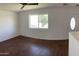 Well-lit living room with hardwood floors, a ceiling fan, and fresh white paint at 1109 E Caldwell St, Phoenix, AZ 85042