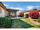 Landscaped backyard featuring lush green grass, colorful trees, and decorative bushes at 12087 S Paiute St, Phoenix, AZ 85044