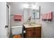 Small, clean bathroom featuring toilet, sink, mirror, and storage under the sink at 12087 S Paiute St, Phoenix, AZ 85044