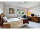 Spacious bedroom with large window, overhead fan, and comfortable furniture, creating a warm and inviting space at 12087 S Paiute St, Phoenix, AZ 85044