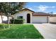 Charming single-story home with lush green lawn, an arched doorway, and a spacious two-car garage at 12087 S Paiute St, Phoenix, AZ 85044