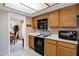 Well-lit kitchen showcases appliances, oak cabinets, white countertops, and a view into a bonus room at 12087 S Paiute St, Phoenix, AZ 85044