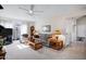 Spacious living room with a ceiling fan, plush seating, and a sliding glass door leading to the outside at 12087 S Paiute St, Phoenix, AZ 85044