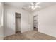 A well-lit bedroom with carpet, a ceiling fan and a closet with sliding doors at 14915 W Port Royale Ln, Surprise, AZ 85379