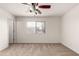 A carpeted bedroom with a window and ceiling fan, offering a comfortable living space at 14915 W Port Royale Ln, Surprise, AZ 85379