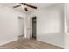 A clean bedroom featuring carpeted floors, a ceiling fan, and access to a closet and another room at 14915 W Port Royale Ln, Surprise, AZ 85379