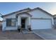 Inviting single-story home featuring a well-maintained front yard and a two-car garage at 14915 W Port Royale Ln, Surprise, AZ 85379