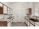 Well-lit kitchen with white cabinetry, modern appliances, and tile flooring for easy maintenance at 14915 W Port Royale Ln, Surprise, AZ 85379