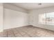 Bright living room featuring tile flooring, neutral walls, and a large window allowing ample natural light at 14915 W Port Royale Ln, Surprise, AZ 85379