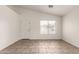 Bright living room featuring tile flooring, neutral walls, and a large window allowing ample natural light at 14915 W Port Royale Ln, Surprise, AZ 85379