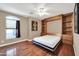 Bedroom with wood floors, Murphy bed, and ample storage at 14949 W Robson Cir, Goodyear, AZ 85395