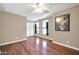 Bedroom with hardwood floors, ceiling fan, and arched windows at 14949 W Robson Cir, Goodyear, AZ 85395