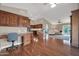 Open kitchen with wood cabinetry, island, and hardwood floors at 14949 W Robson Cir, Goodyear, AZ 85395