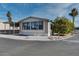 Mobile home exterior with paved driveway and landscaping at 17200 W Bell Rd # 1581, Surprise, AZ 85374