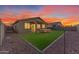 Artificial turf backyard with a wooden bench and covered patio at 17574 W Cardinal Dr, Goodyear, AZ 85338