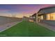 Artificial turf backyard with a covered patio and seating area at 17574 W Cardinal Dr, Goodyear, AZ 85338